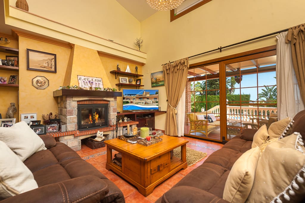 Vista de salón con doble altura y chimenea