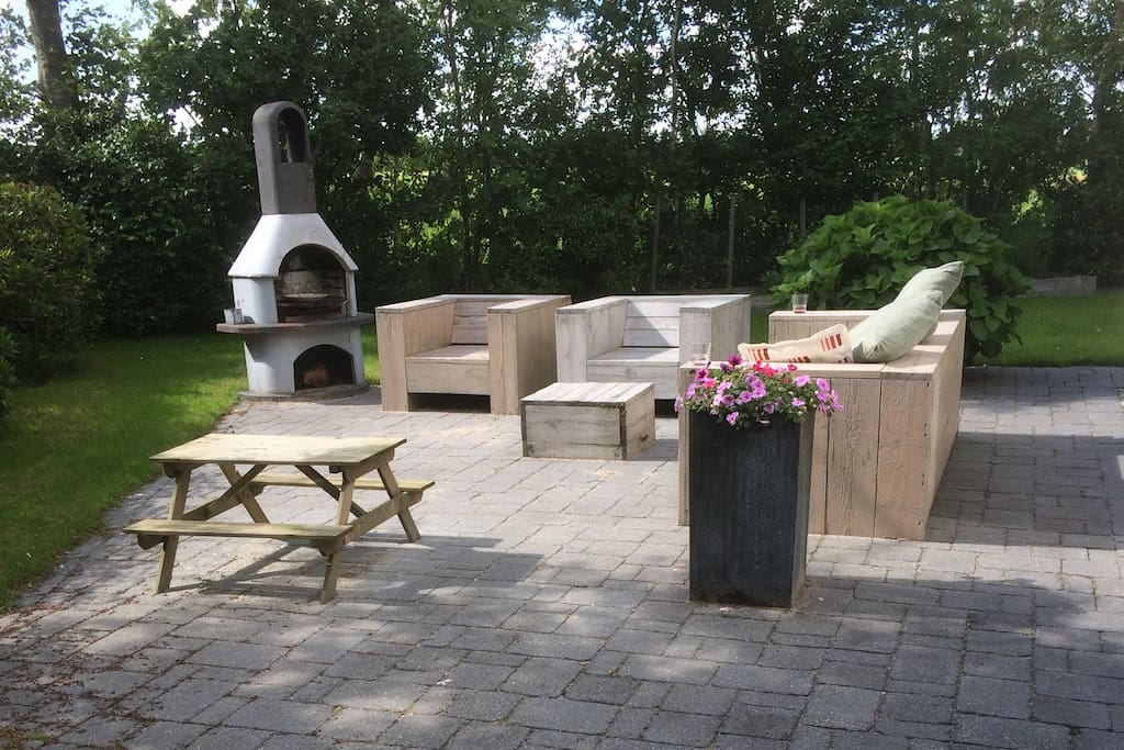 Terras met loungebanken en buitenhaard / BBQ