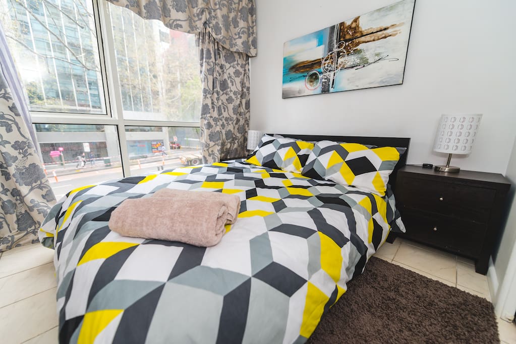 A bedroom with a double sized bed & plush pillows.