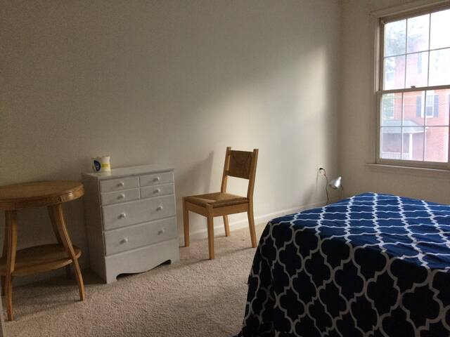 Single bed, table and closet.