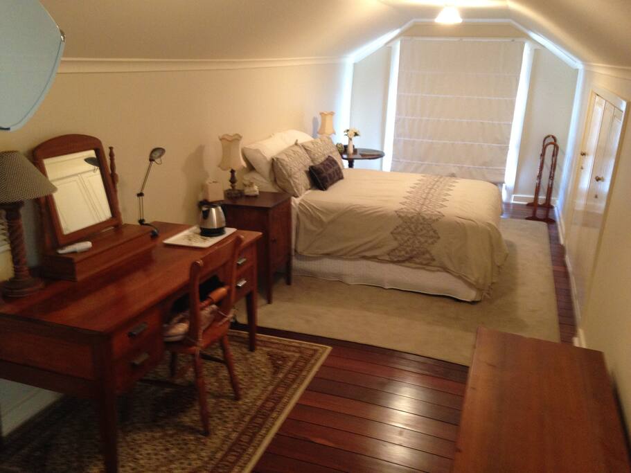 Spacious bedroom with queen size bed & desk.