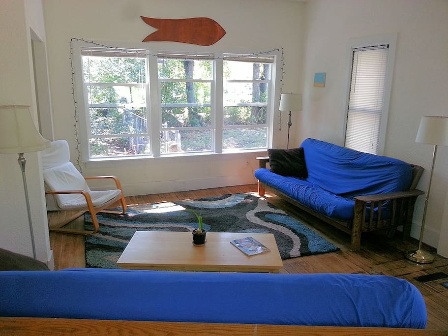Bright, sunny, comfy living room with two futons.
