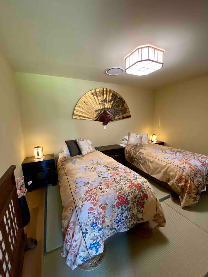 Chambre double moderne de style japonais avec éléments japonais, ventilateur à main, Tokonoma (alcôve), tapis de tatami faits de précipitation, Shoji (fenêtres coulissantes en papier), Tsuitate (cloison portable à panneaux simples.