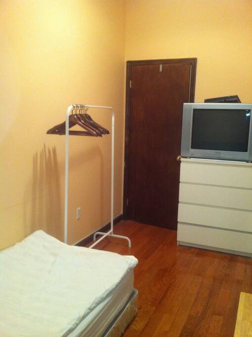 Front of the room: tv, hangers and door.