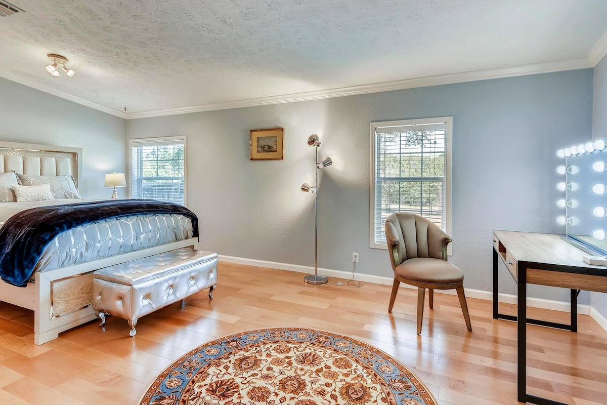 ห้องมาสเตอร์สวีทพร้อมเตียงควีนไซส์มีกระจกแต่งหน้าแบบมืออาชีพพร้อมไฟและงานศิลปะดั้งเดิม