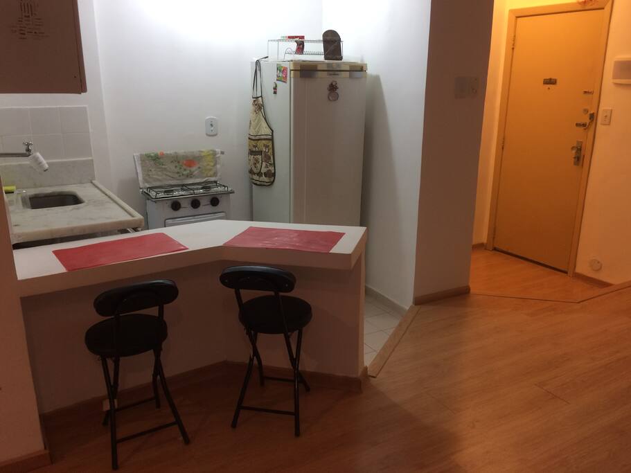 Cozinha americana e porta do apartamento.