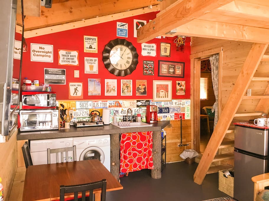 Vintage signs grace the wall at Chickadee. In the back right is the door to the bedroom and beyond it the bathroom.