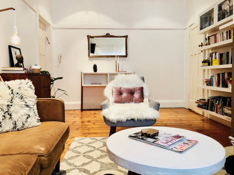 Spacious Lounge with leather couch, comfortable armchair, flat screen TV, DVD, bookshelves, cabinet with board games.