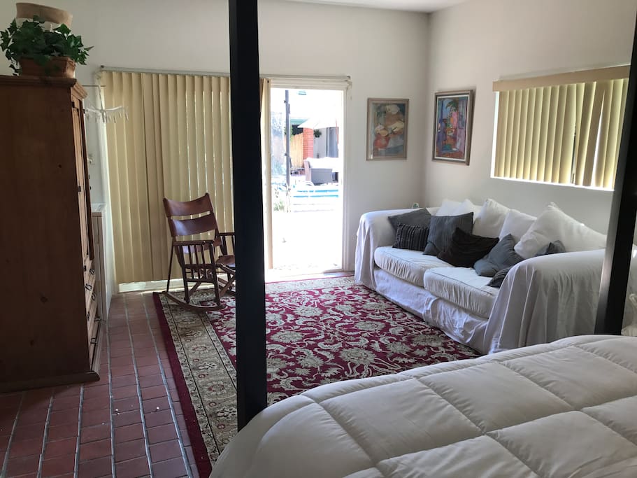 View from inside large room to outside garden/patio/pool area thru sliding glass door