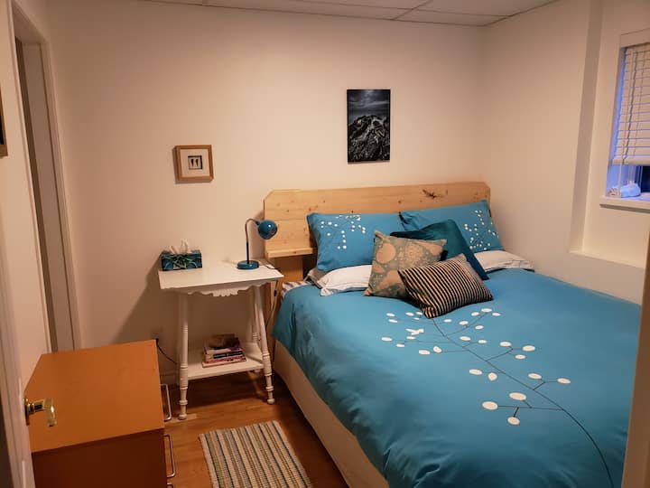 Queen bed in primary guest bedroom, small and cozy.