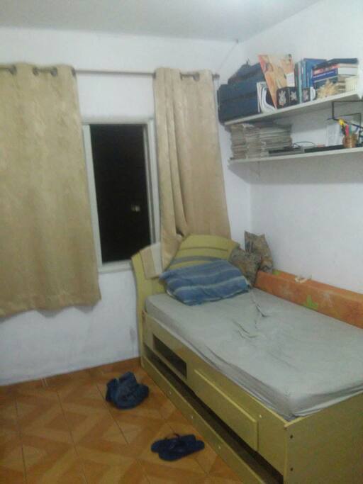 Quarto com Cama e janela para rua.