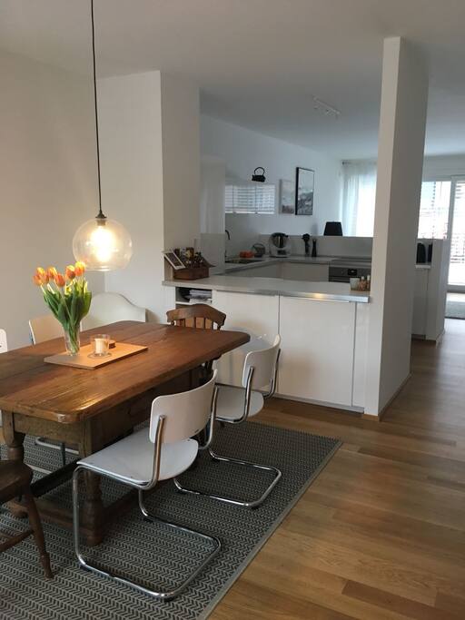 There is a nice dining table in the living room adjacent to the kitchen