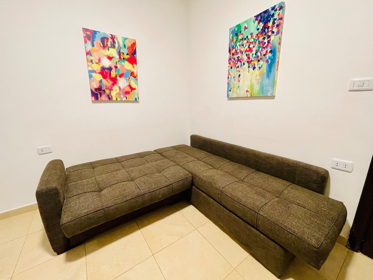 Kitanda cha sofa kizuri sana. Inaweza kubadilishwa kwa urahisi kuwa kitanda.
Michoro miwili ya Sanaa kwenye ukuta imefanywa na kusainiwa na msanii wa karibu wa Jordan ili kuhamasisha sehemu yako ya kukaa.