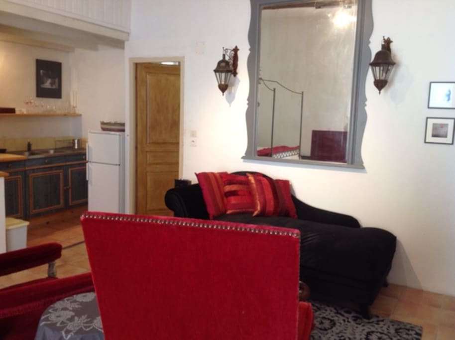 Chaise lounge, Christian Lacroix carpet and pillows, antique red velvet chairs