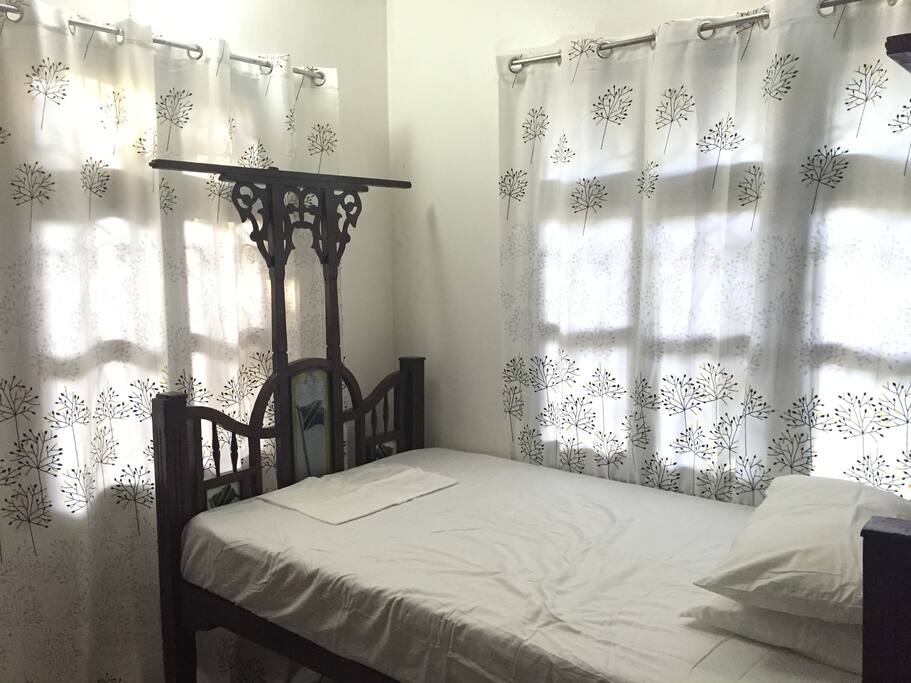 The room has a lot of natural light and a good overhead fan.