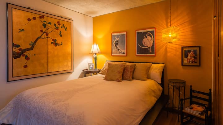 El dormitorio con mostaza incluye un cómodo colchón doble con almohada de alta calidad y una ventana corrediza que se abre al patio.