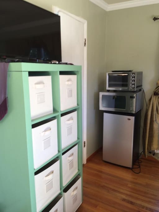 refrigerator, microwave, toaster oven in room.