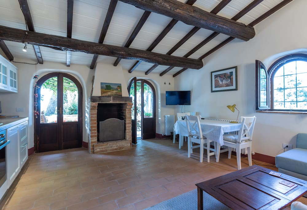Living room and kitchen with direct access to the veranda. An authentic fireplace for cosy evenings