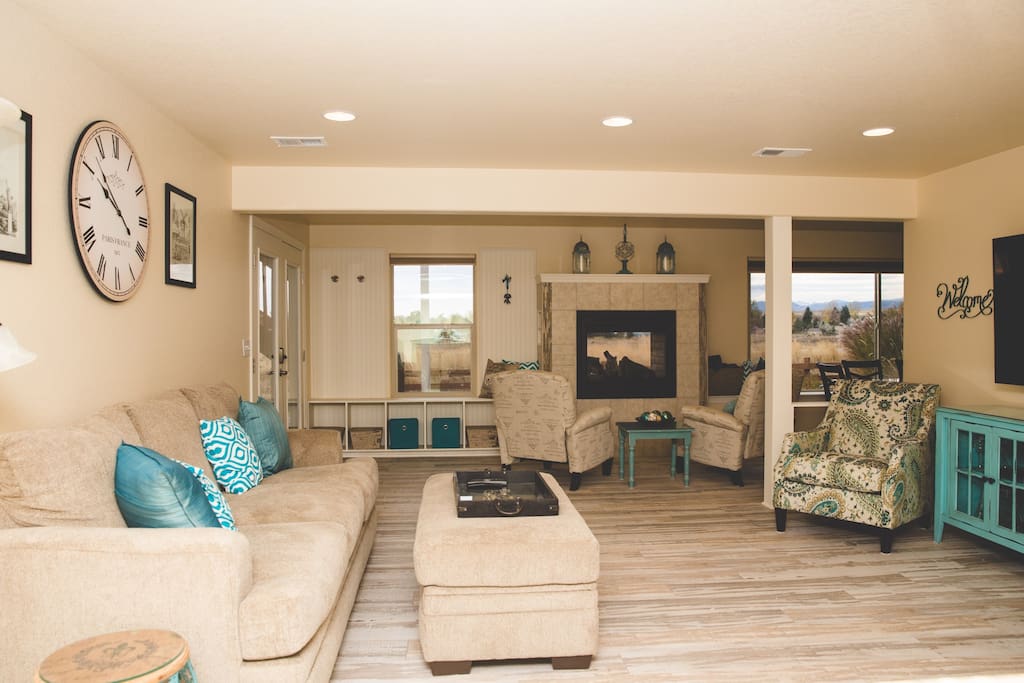 Large living area with comfy seating and beautiful views! The chairs can be moved for cozier arrangements and the recliners by the fireplace are perfect for morning coffee or evening wine.