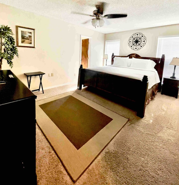 חדר שינה ראשי גדול עם שידה וטלוויזיה בכבלים. גישה לחדר הרחצה הראשי. 