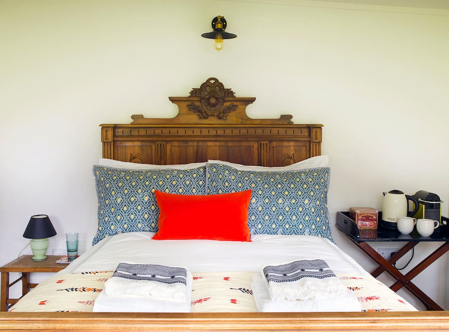 Crisp white bed linen is mixed with colourful, rich textiles for a contemporary look.