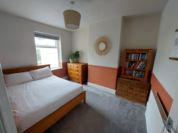 2 ° camera da letto con cassettiera e una serie di libri da prendere in prestito.