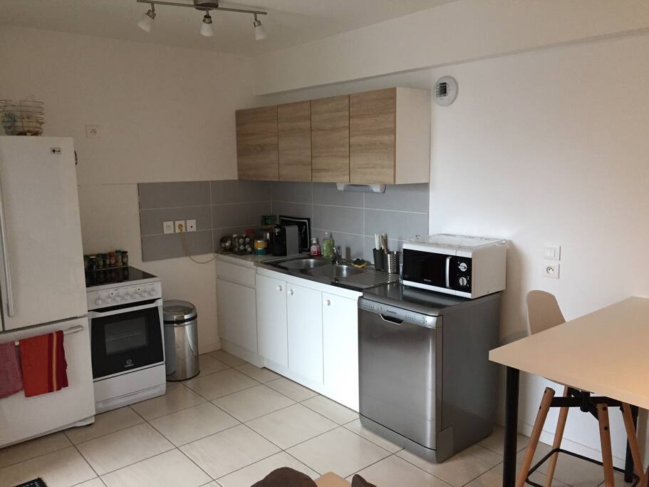 Cuisine avec électroménager et vaisselle à disposition. Table haute & 2 tabourets