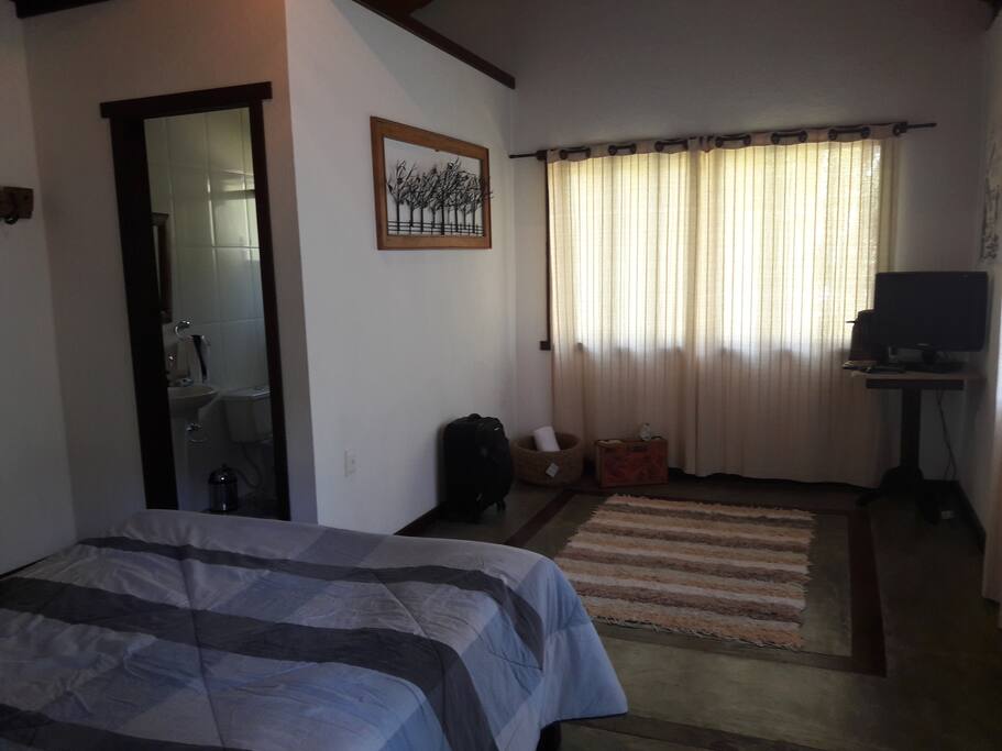 Suíte com tv, lareira e vista para o verde