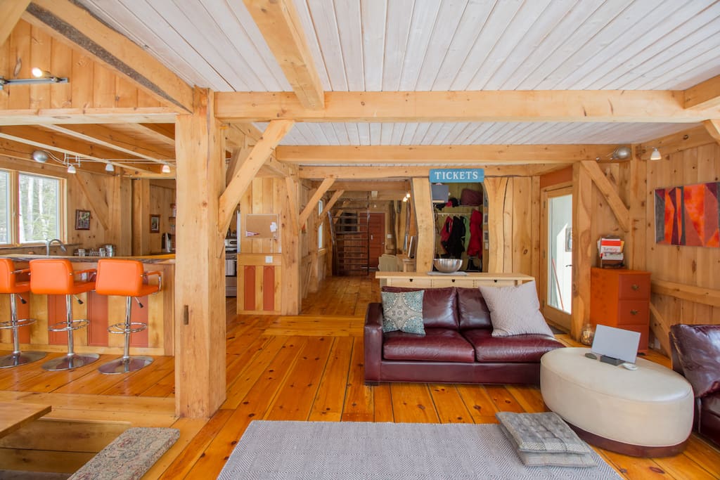 The living room has wide-plank wood floors and cozy couch