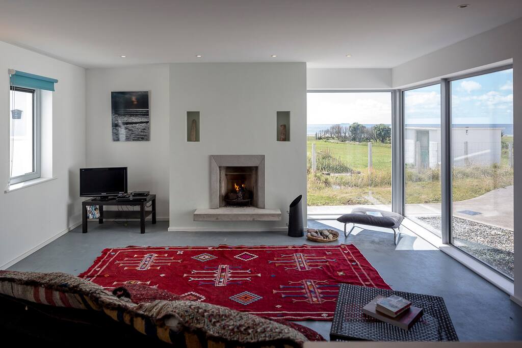 Large sitting room by the ocean with open turf fire and double sofa bed