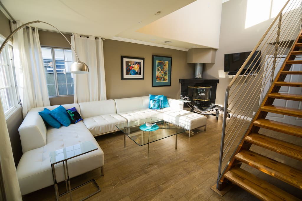Living room with white sectional (new 2016), hardwood floors (2016), LeCorbusier lounge, fireplace.