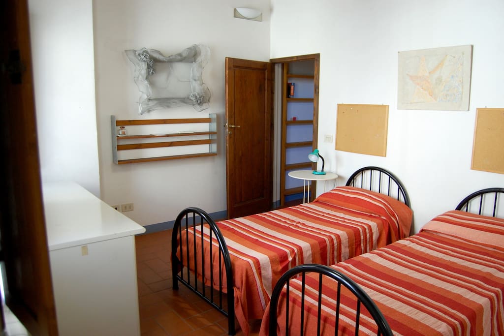 Bedroom with two twin beds, a desk, large wardrobe, en suite bathroom and two windows