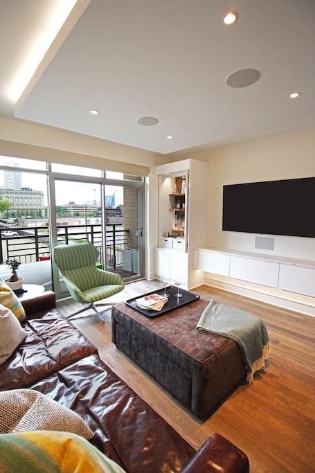 Living room with comfortable seating, 65" 4K LG OLED television, and Dolby atmos surround sound.