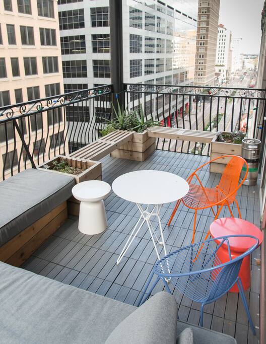 Large balcony on Main Street features custom made day bed, seating and planters