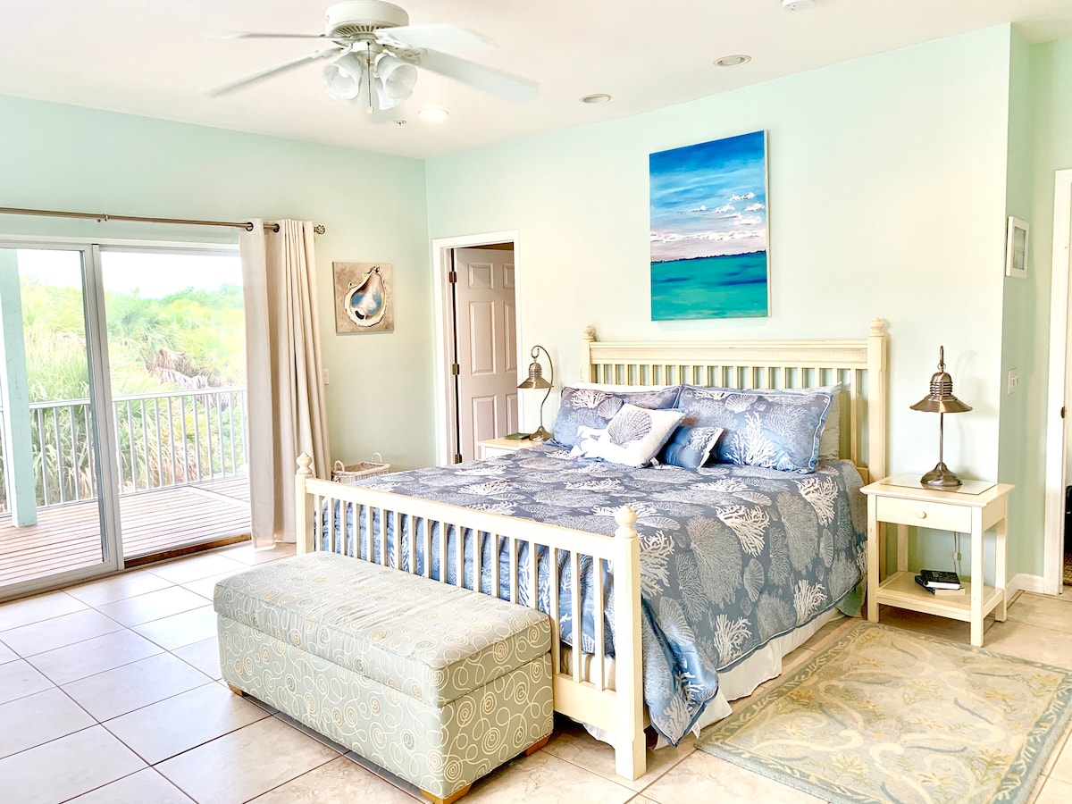 غرفة نوم رئيسية مع شرفة كبيرة وخاصة وشاشة مغلقة. 