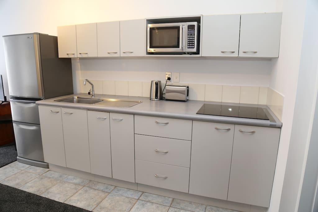 Kitchenette with microwave and full fridge, plates and cutlery etc.