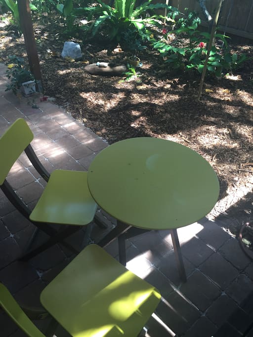 Outdoor chairs and table undercover paved area.