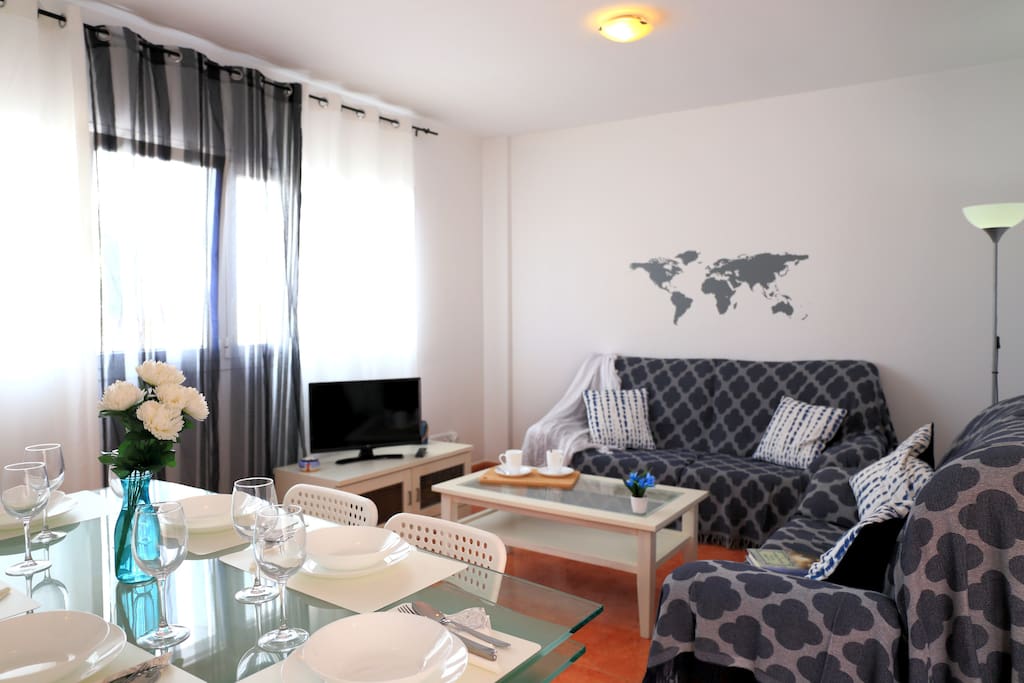 Woonkamer met eethoek voor 6 personen, twee bankstellen, Smart-Tv en WiFi.