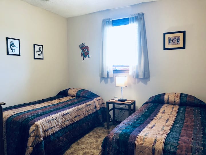 1 of 3 downstairs bedrooms with 2 single beds.
