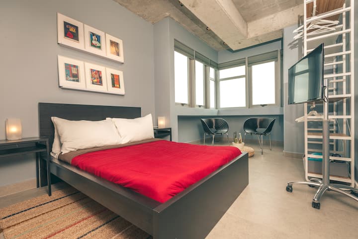 Second bedroom with corner window overlooking the ocean. Full size bed, smart TV and seating area.