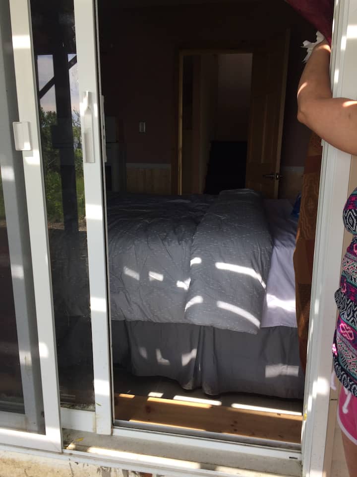 דלת הזזה מזכוכית מחדר שינה קטן החוצה הפונה לקו המים
