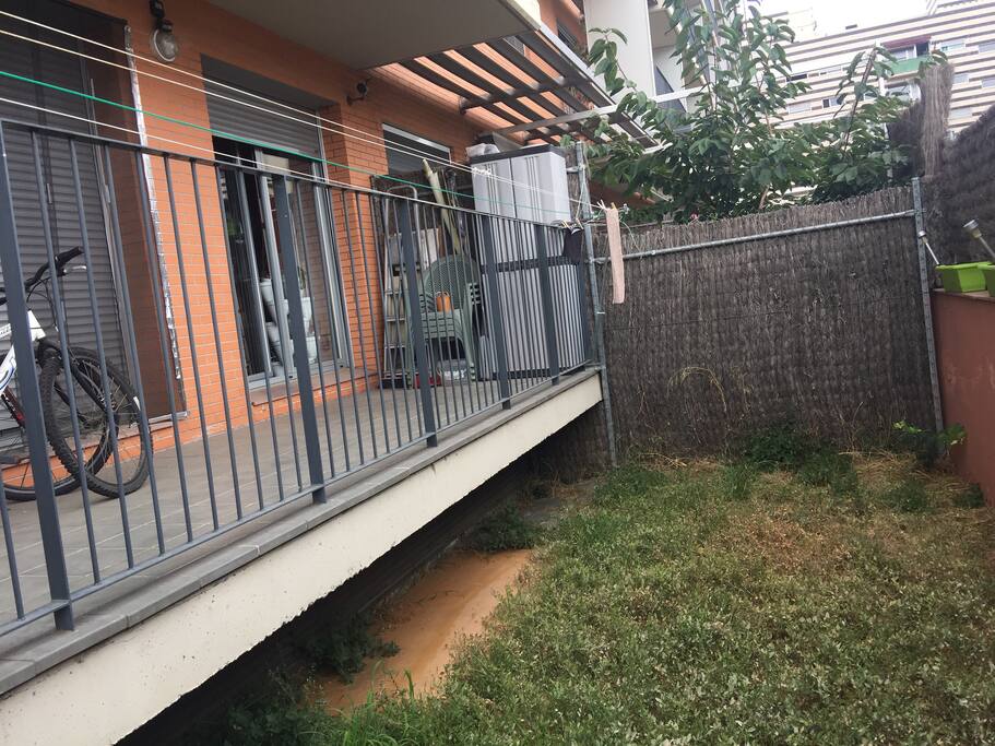 Terraza con jardín. Hay mesa y sillas, pero si se quiere también dentro hay mucha luz. Hay mosquitera para los insectos.