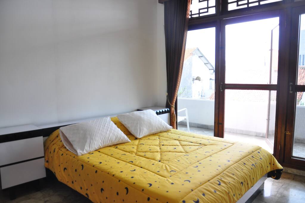 Very well-lit bedroom with a balcony and a garden view