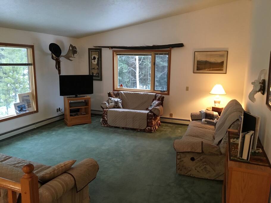 The living room is part of an open concept upstairs with a large picture window facing the river.