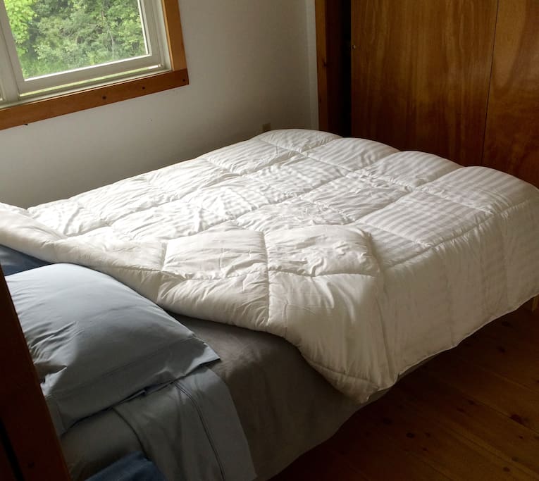 The queen sized bed in the back bedroom.