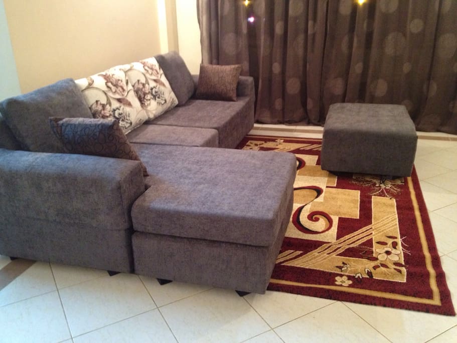 More view of the sitting area carpeted , puff to rest your feet as you watch tv.or look through the glass sliding doors facing Mombasa road.