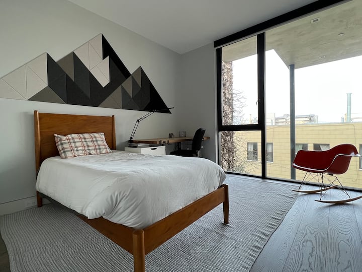 Dormitorio doble con colchón en el suelo disponible.  Amplia ventana del suelo al techo con luz natural con persianas para la privacidad y la noche.