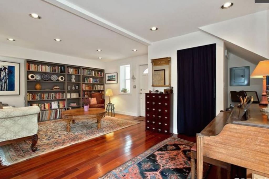 Living room and entry way with spinet piano.