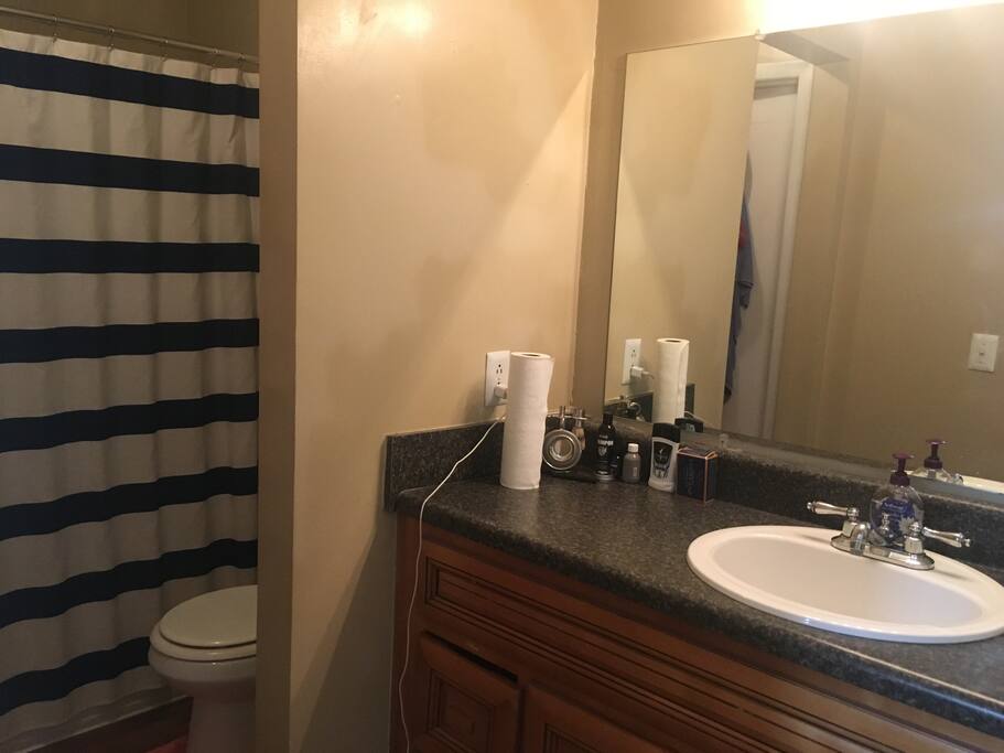 1 shared bathroom has great lighting, bath tub and shower.