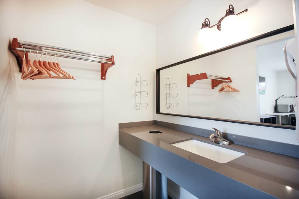 Washroom w/ stone counters, closet rack, hairdryer, etc